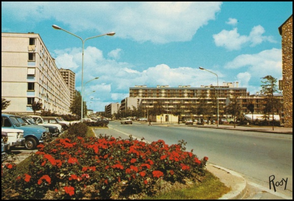 L'avenue Winston Churchill avec des fleurs, et de jeunes arbres. La Maison de quartier n'a pas encore été construite. (reproduction d'une carte postale)